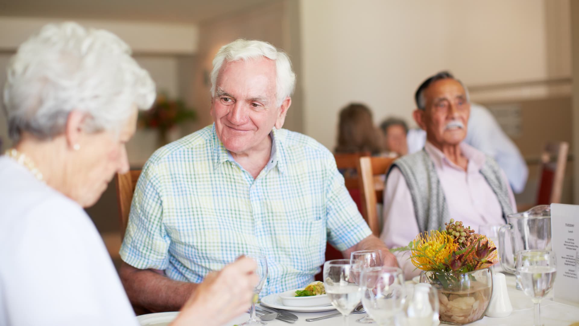 A group of senior citizens enjoying a luncheon together in a retirement home