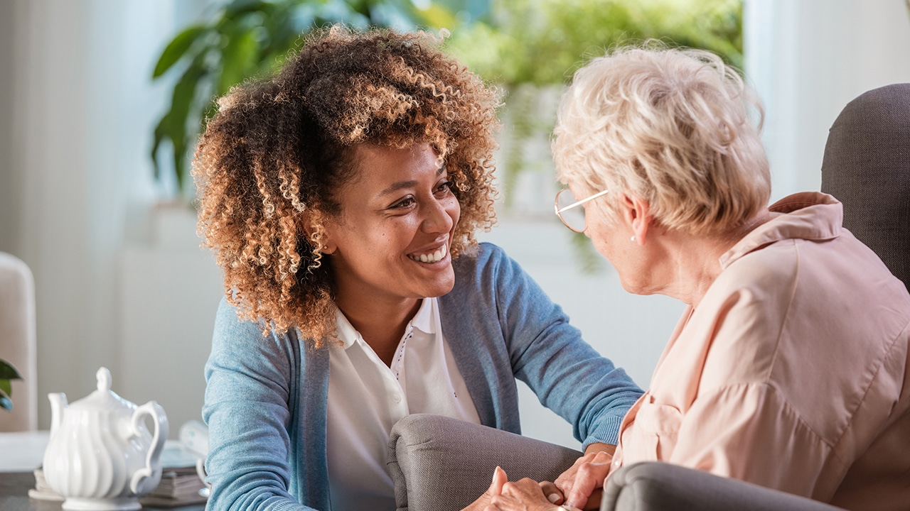 Home caregiver taking care of elderly woman