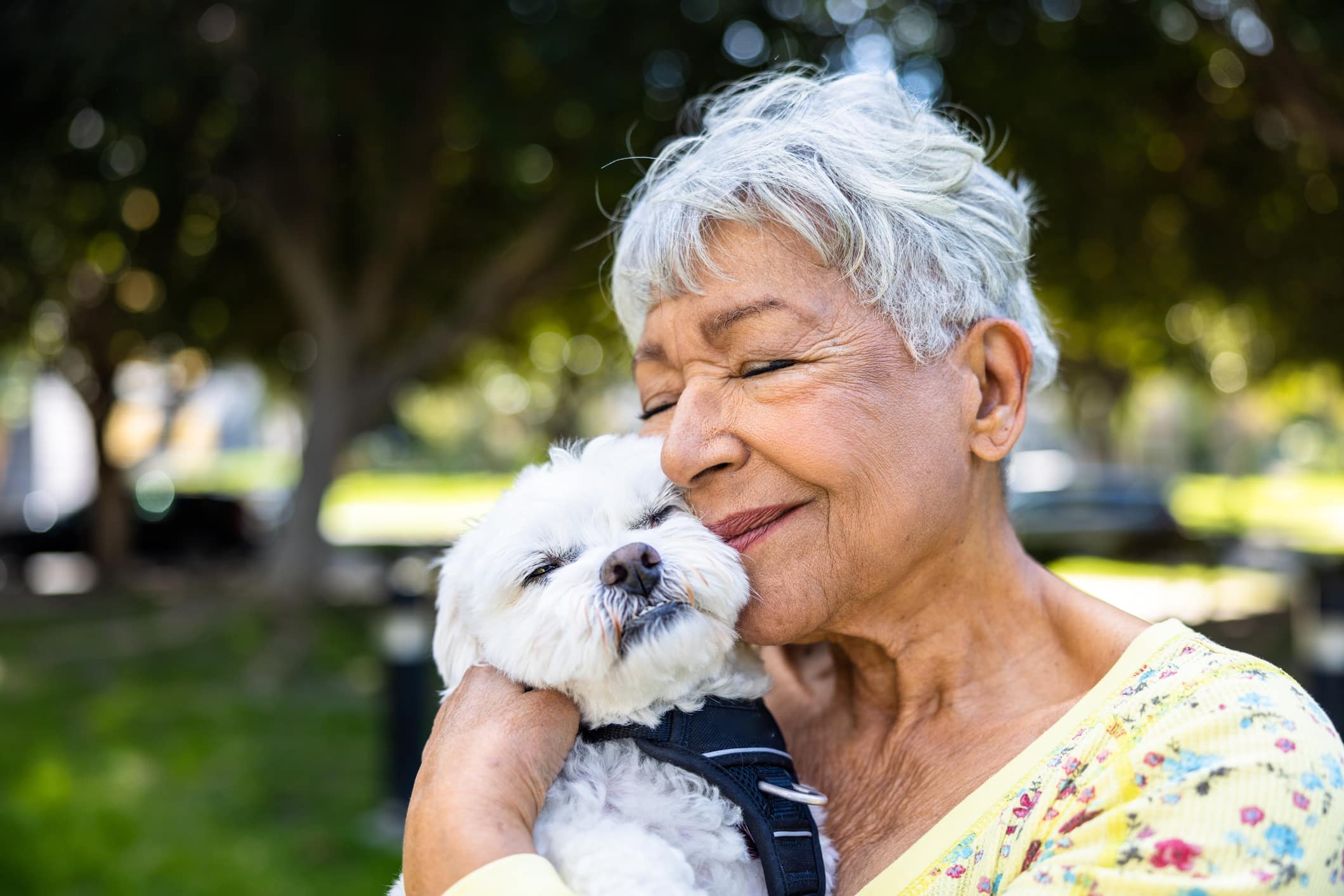 A mixed race senior woman holding her puppy outdoors